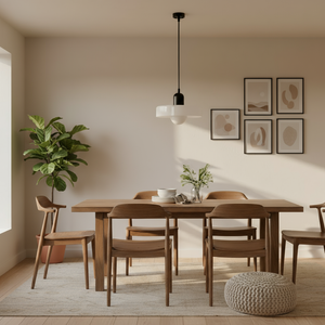 Dining room with wooden table and chairs, plant, and wall art.