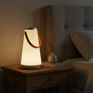 Lamp on a bedside table with a cozy bedroom setting