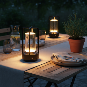 Outdoor table setting with lit lanterns and dinnerware at night.