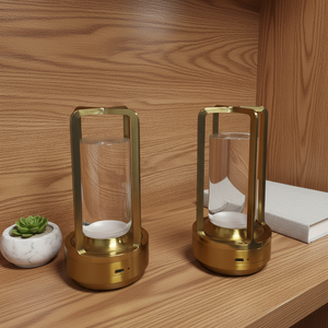 Two gold lanterns on a wooden surface with a small plant and book in the background.