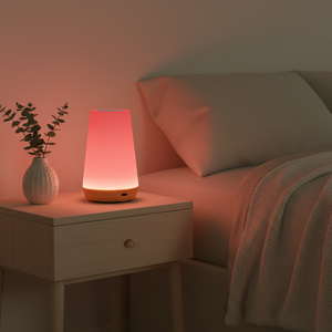 Pink night light on a bedside table next to a bed in a dimly lit room