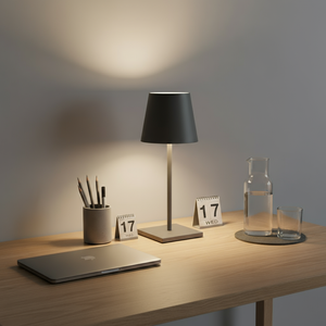 Desk setup with a lamp, laptop, and decorative items on a wooden surface.
