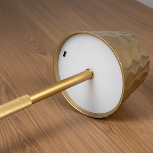 A golden modern lamp on a wooden table