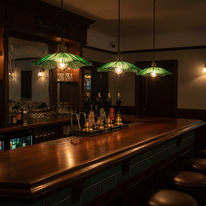 Dark bar with wooden counter, green pendant lights, and various bottles.