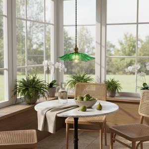 Modern dining room with a round table, chairs, and green pendant light.