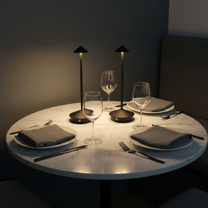 Dining table set with plates, glasses, and cutlery in a dimly lit room.