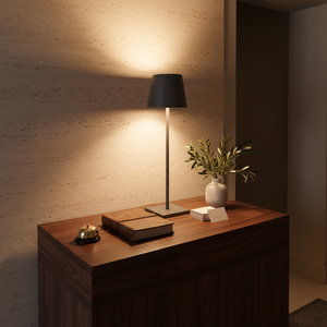 Wooden side table with a lamp, book, and small plant in a dimly lit room.