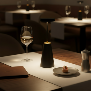 Lamp on a table with a glass of water and a dessert in a restaurant setting