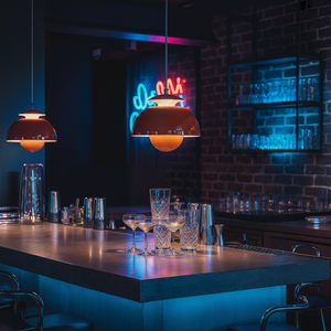 Bar counter with cocktail glasses and neon sign in a dimly lit bar.
