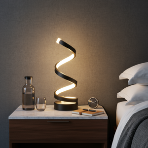 Spiral table lamp on a nightstand next to a bed with pillows