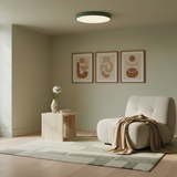 Modern living room with a beige armchair, wooden side table, and abstract wall art.