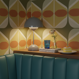 Decorative room interior with patterned wall, table, and green sofa.