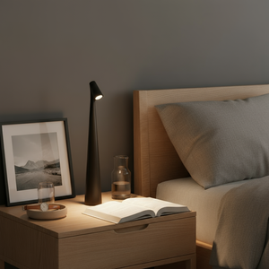 Bedroom scene with a nightstand, lamp, and open book.