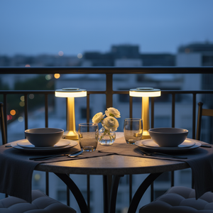 Dining table set with bowls, glasses, and a vase of flowers on a balcony at night.