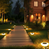 Wooden pathway leading to a house with solar lights illuminating the area